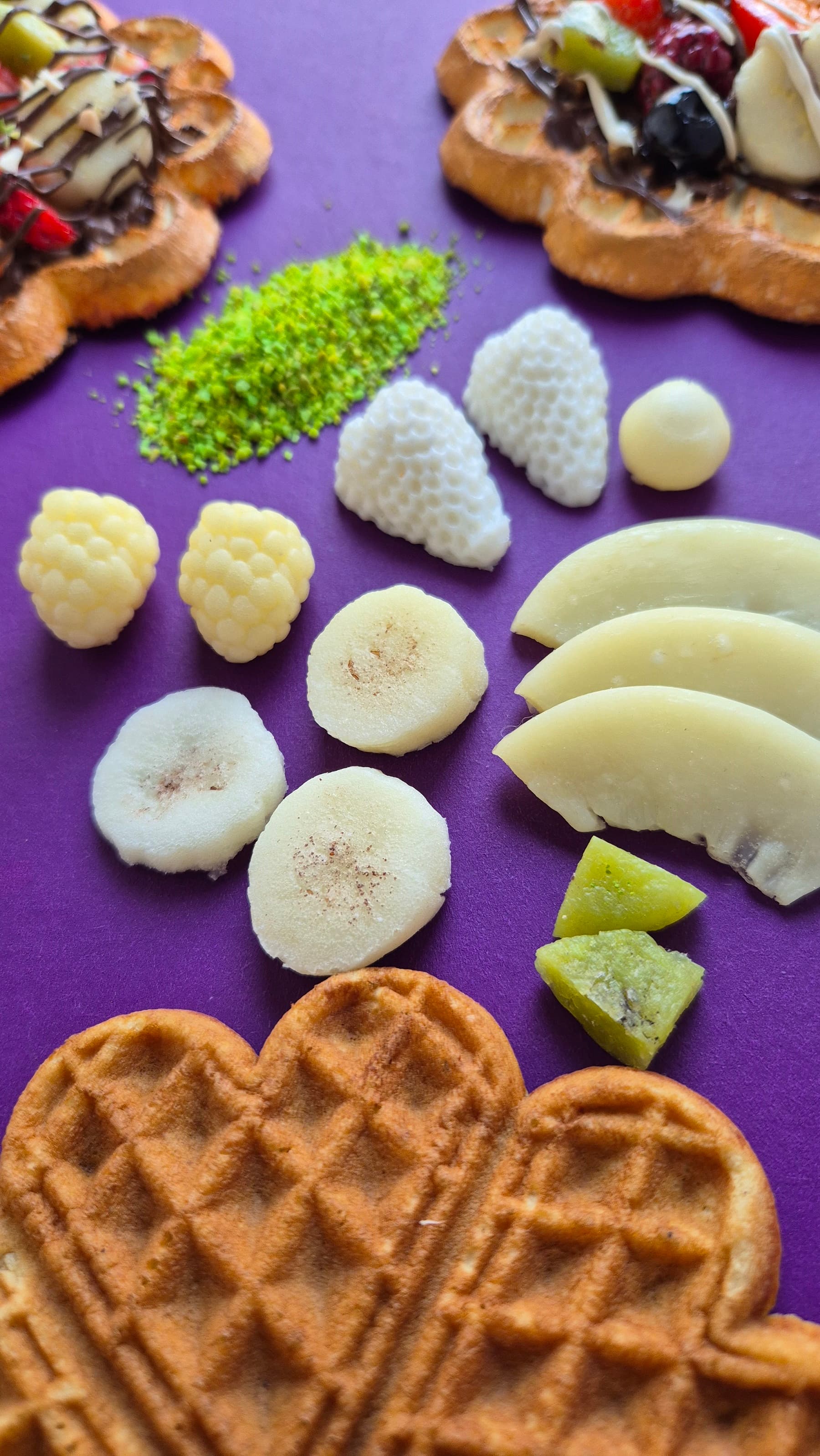 El yapımı muz, şeftali ve ahududu replikaları ile waffle yüzeyinin yakın planı